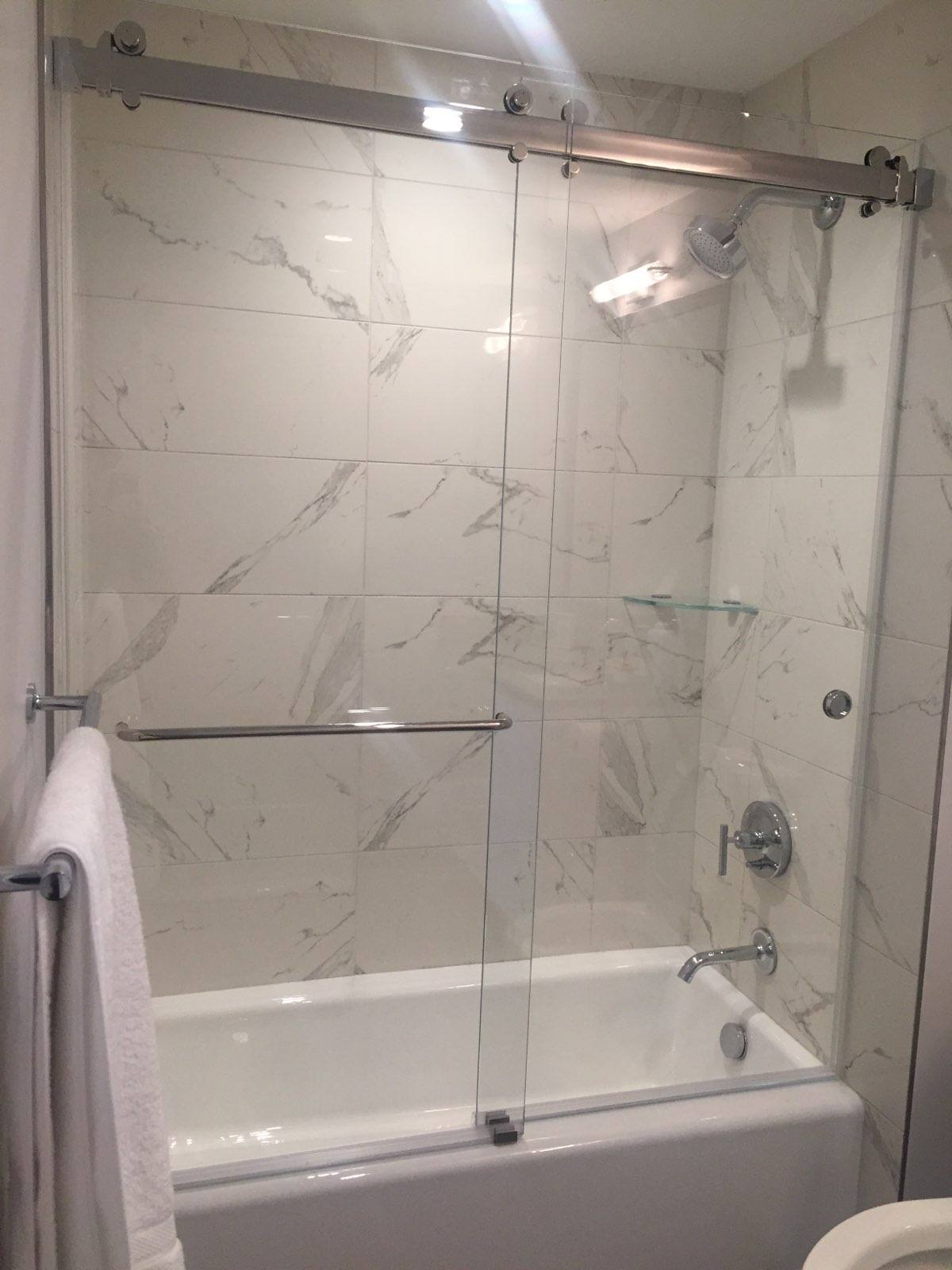 Sliding glass doors fitted above a bathtub.
