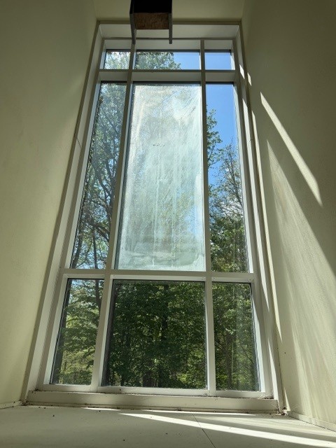 A tall window with a cloudy central glass pane beside clear glass