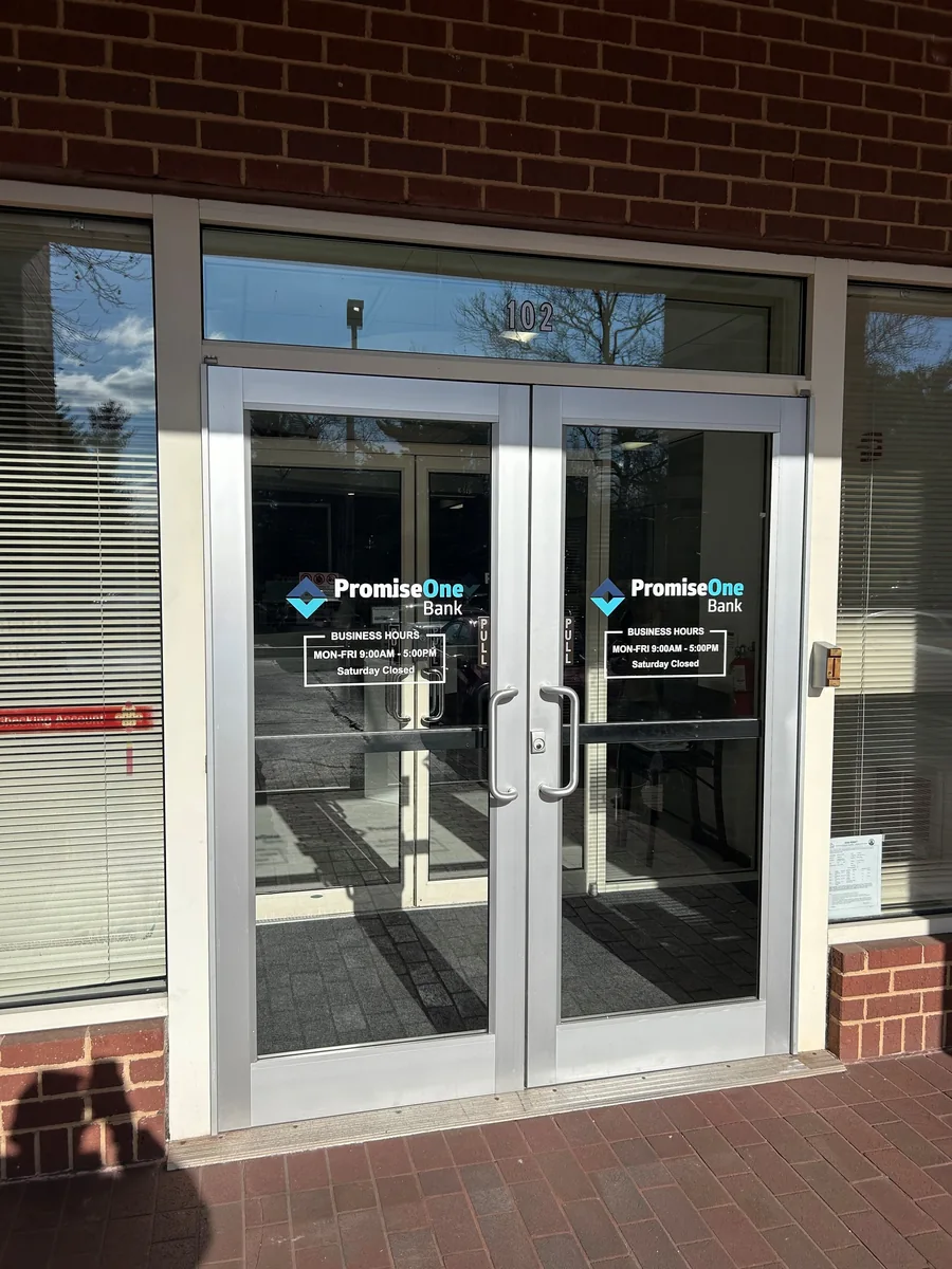 Aluminum storefront glass entrance doors with matching side windows.