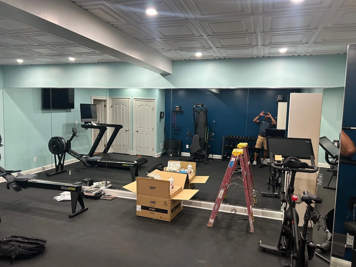Floor-to-ceiling mirror wall installed in a home gym.
