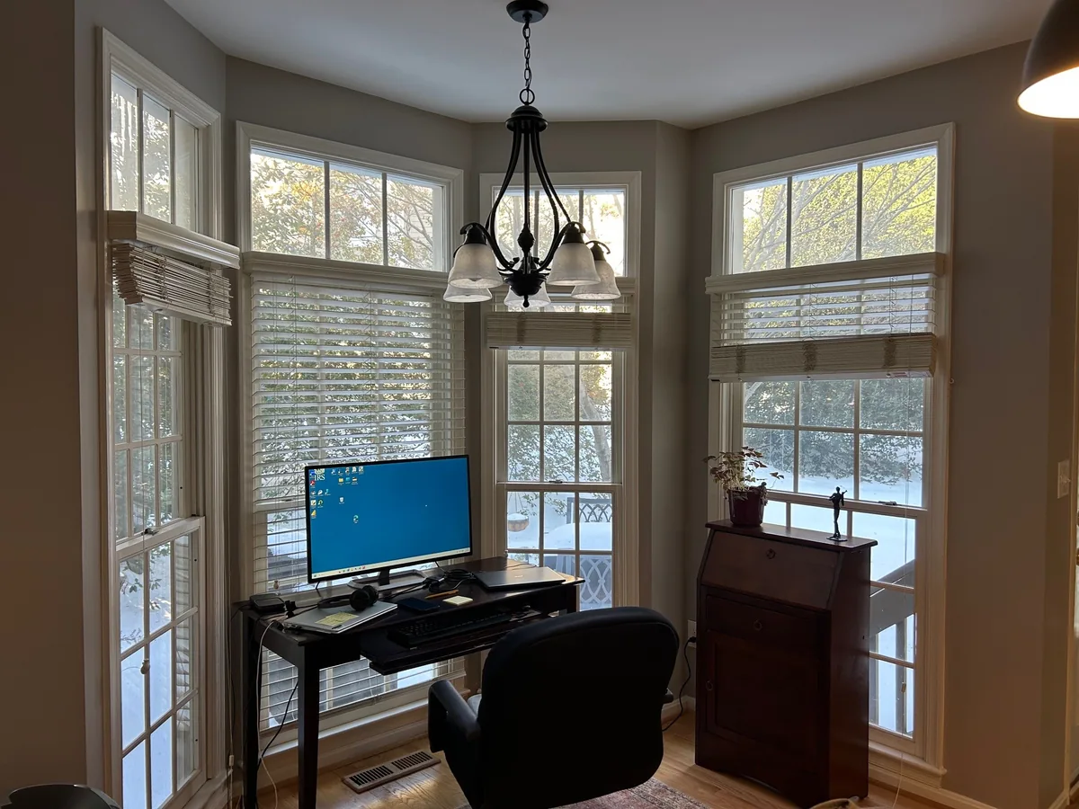 Tall white windows with rectangular transoms around a room
