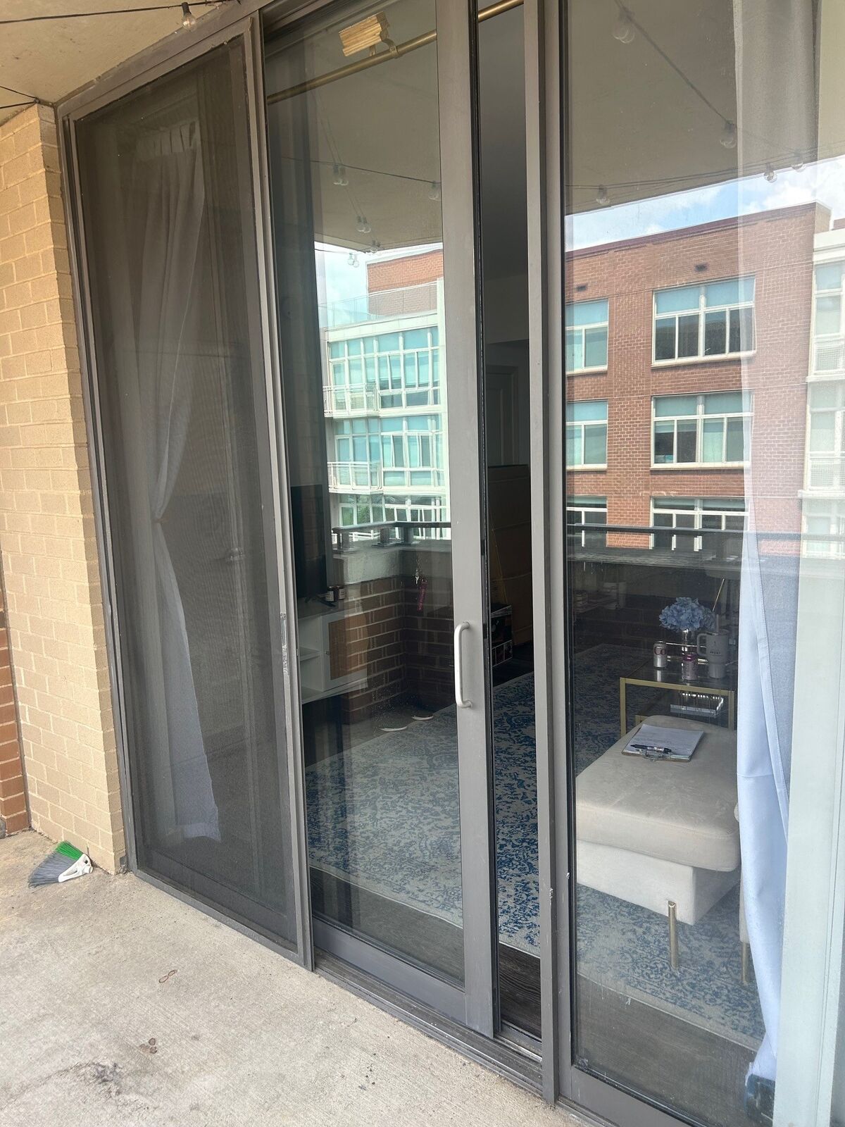 A dark-framed sliding glass door opening onto a condo balcony