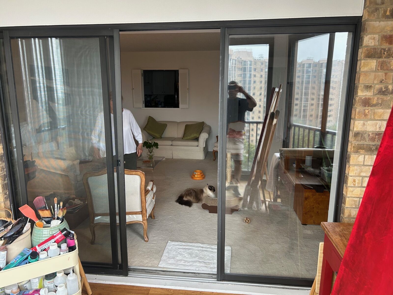 A wide sliding glass doorway in an occupied apartment during a service visit