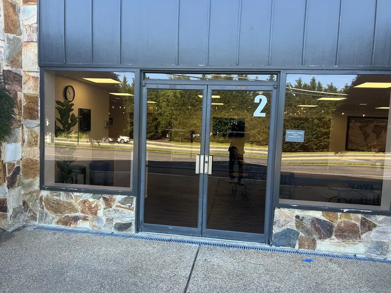 Double glass entry doors have glazed sidelights above a stone base.