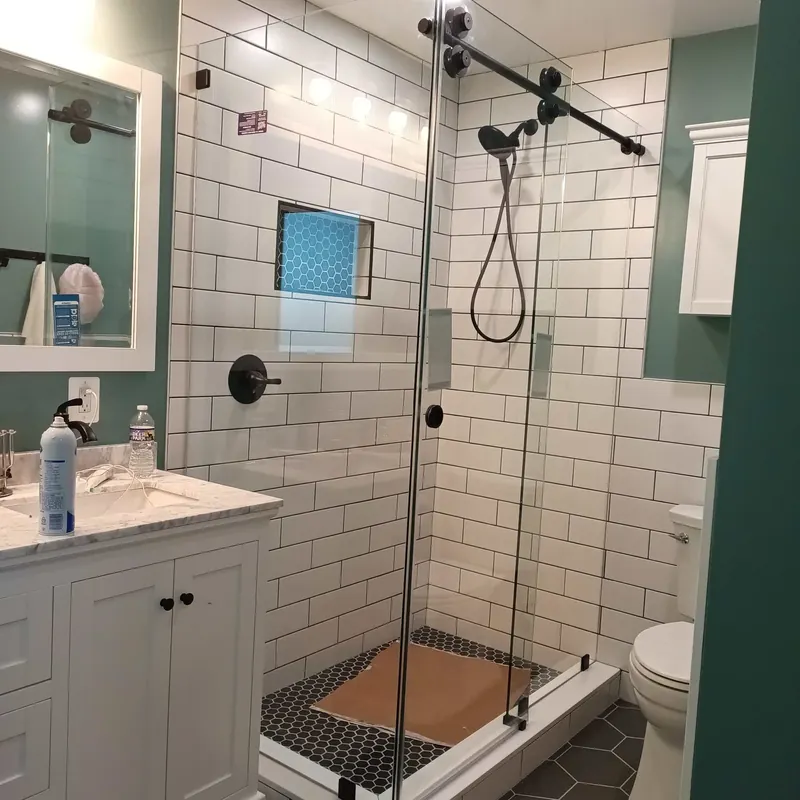 Black hardware shower with white subway tile.