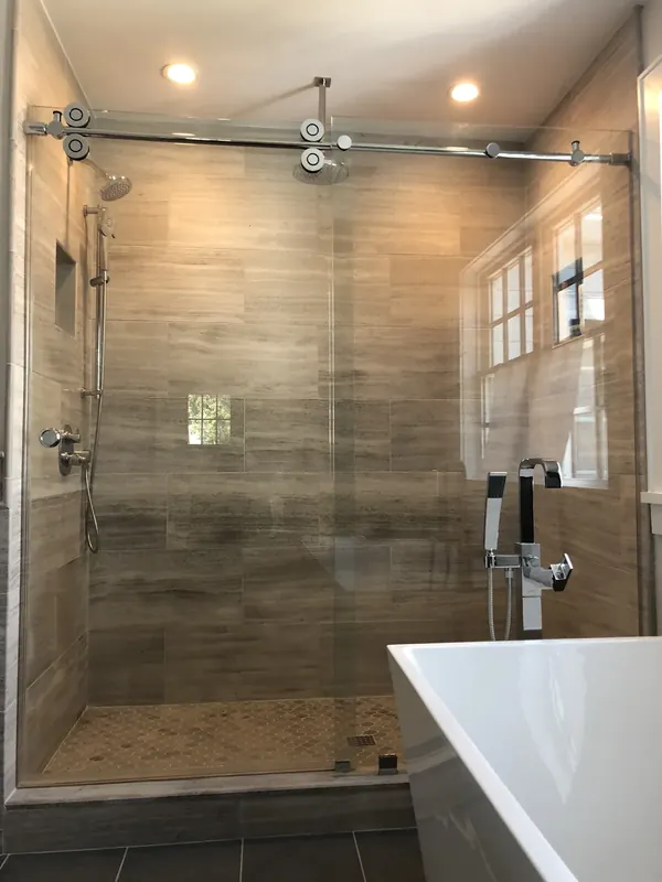 Sliding shower enclosure with wood look tile.