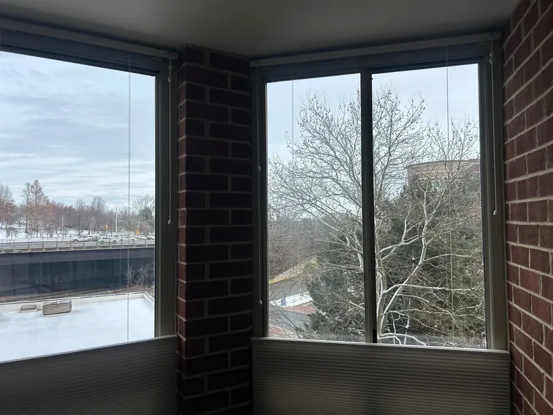 Corner windows against exposed brick walls.
