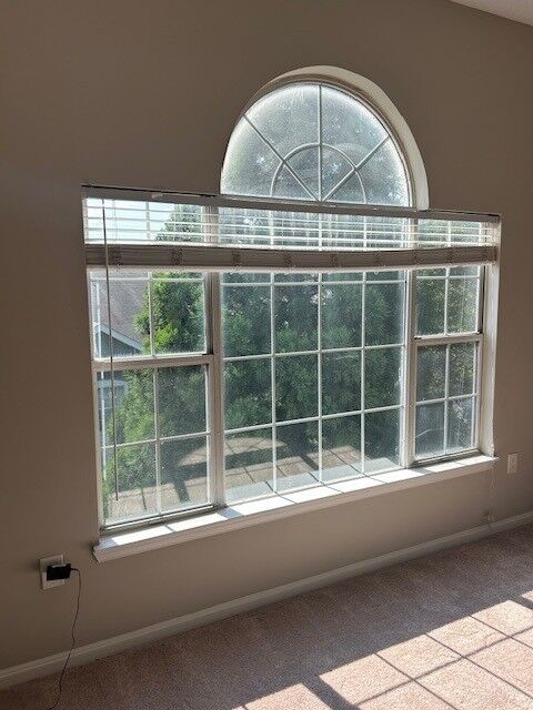A wide window with grids and an arched transom above it