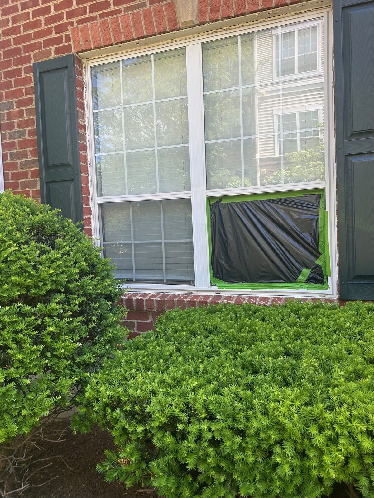 A window with a temporary dark covering over its lower pane