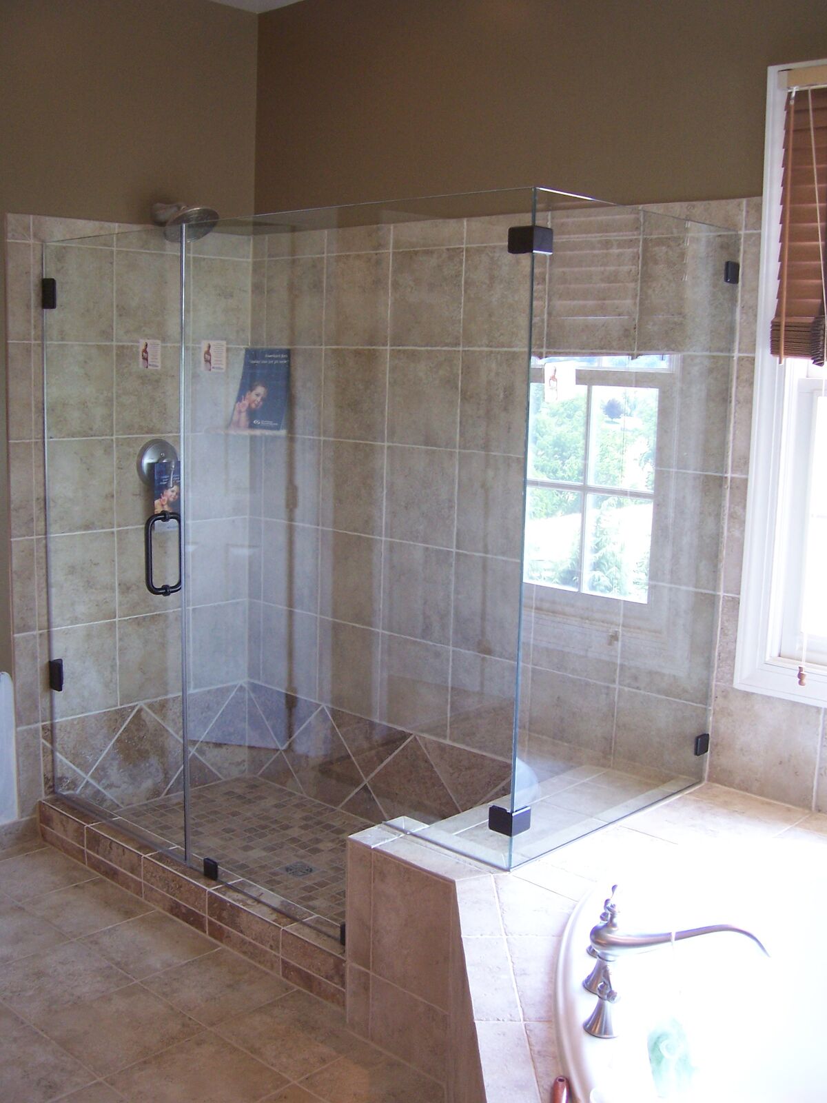 A glass shower with a notched side panel fitted over a tub surround