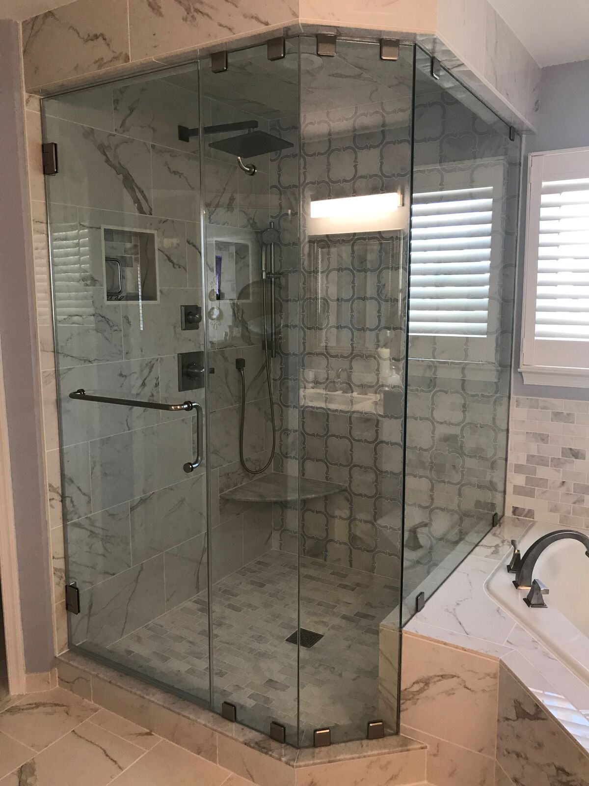 Full-height neo-angle glass shower enclosure in a bathroom corner