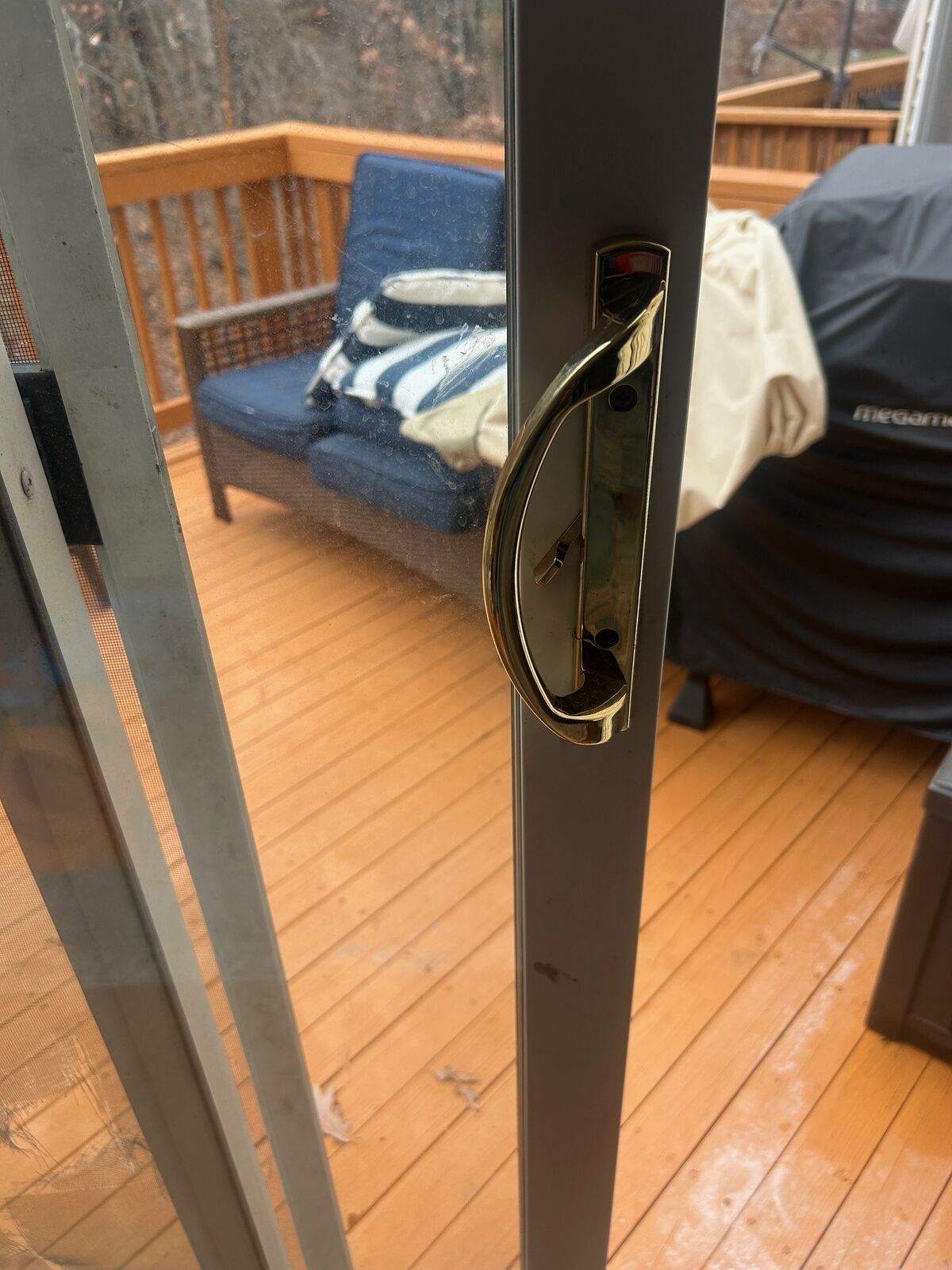 Close-up of a patio door pull handle and thumb-turn lock