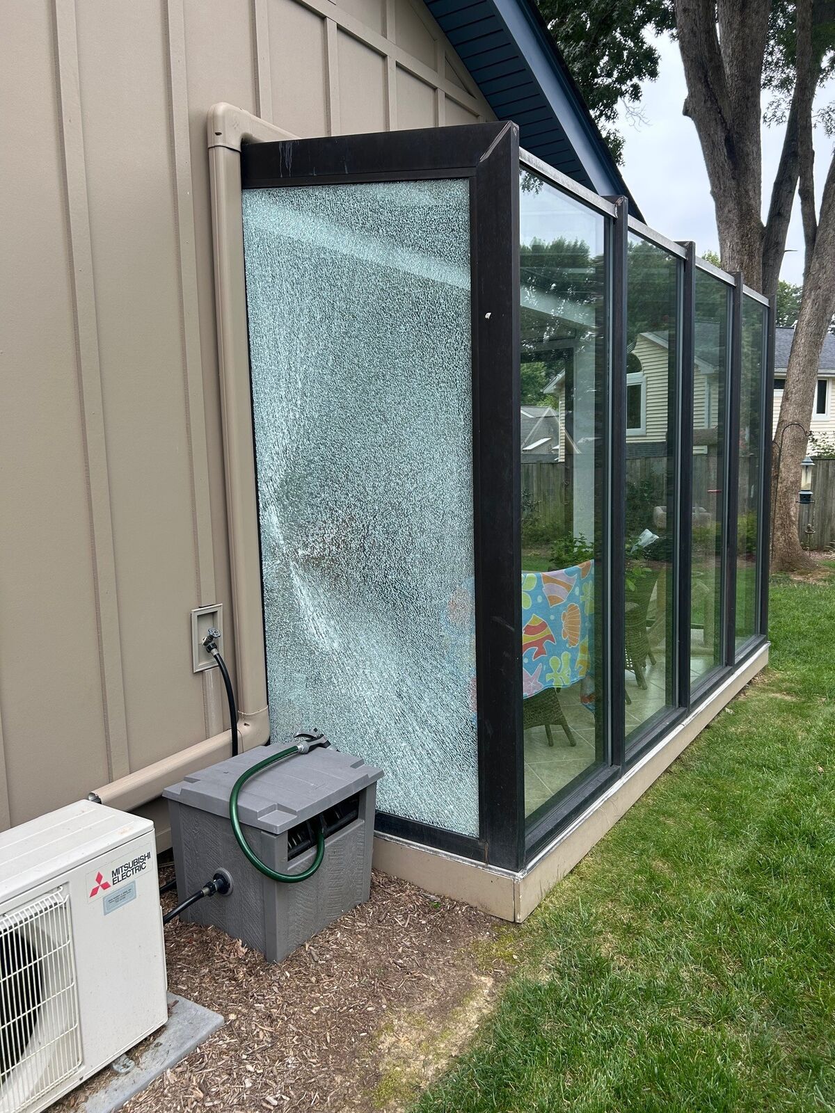 A sunroom with a visibly shattered glass panel