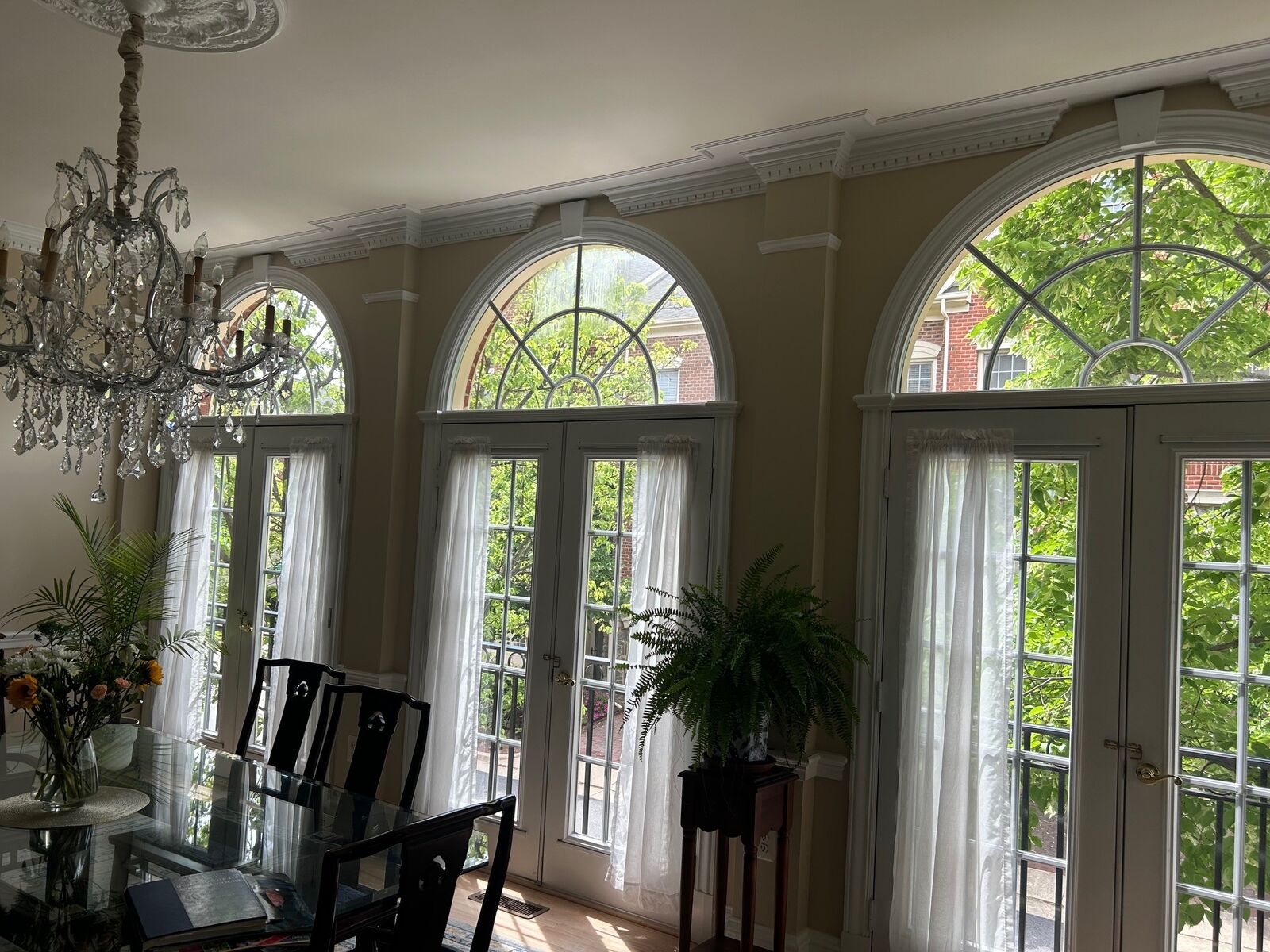 Three pairs of French patio doors under arched transoms in a bright dining room