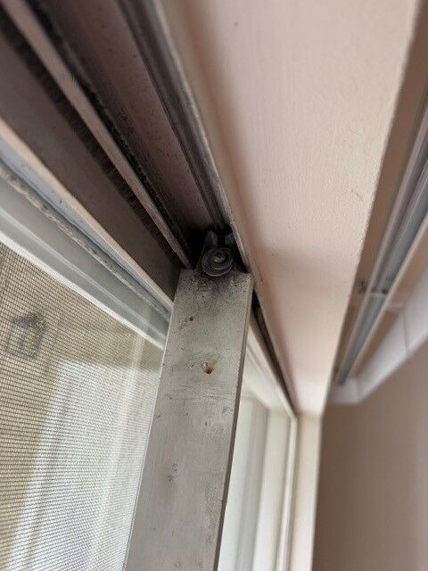 Close-up of the bottom track and roller area of a sliding patio door