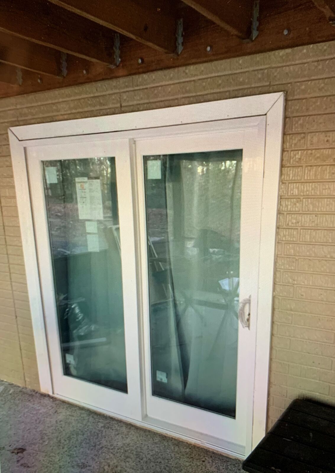 A white sliding patio door set in a brick wall
