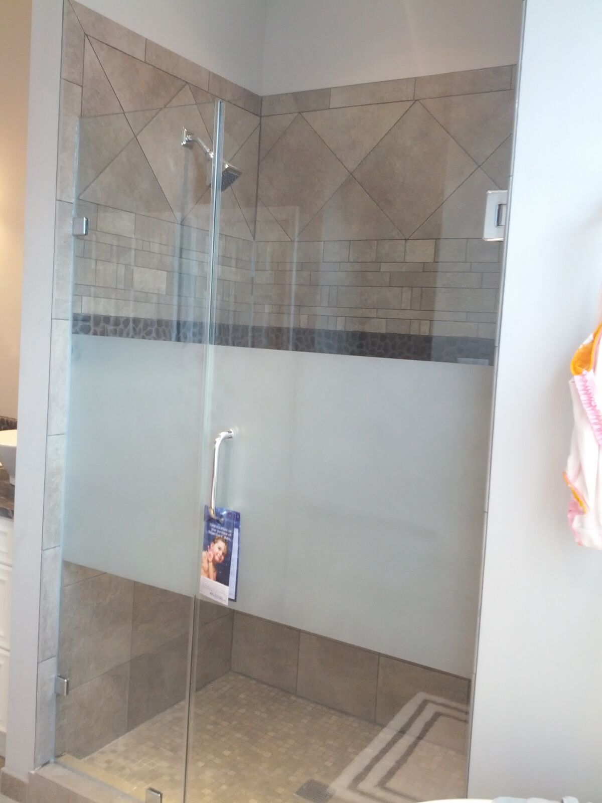 A frameless shower with a broad frosted privacy stripe across the glass