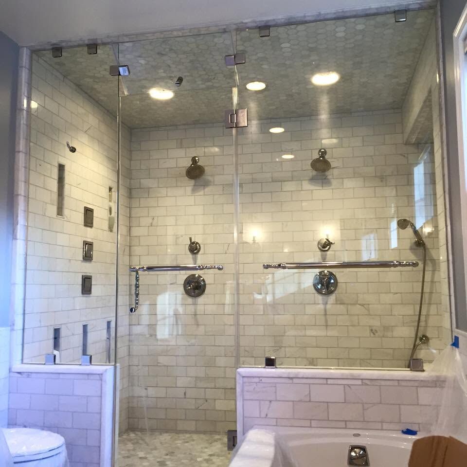 A full-height glass steam shower enclosure with white subway tile
