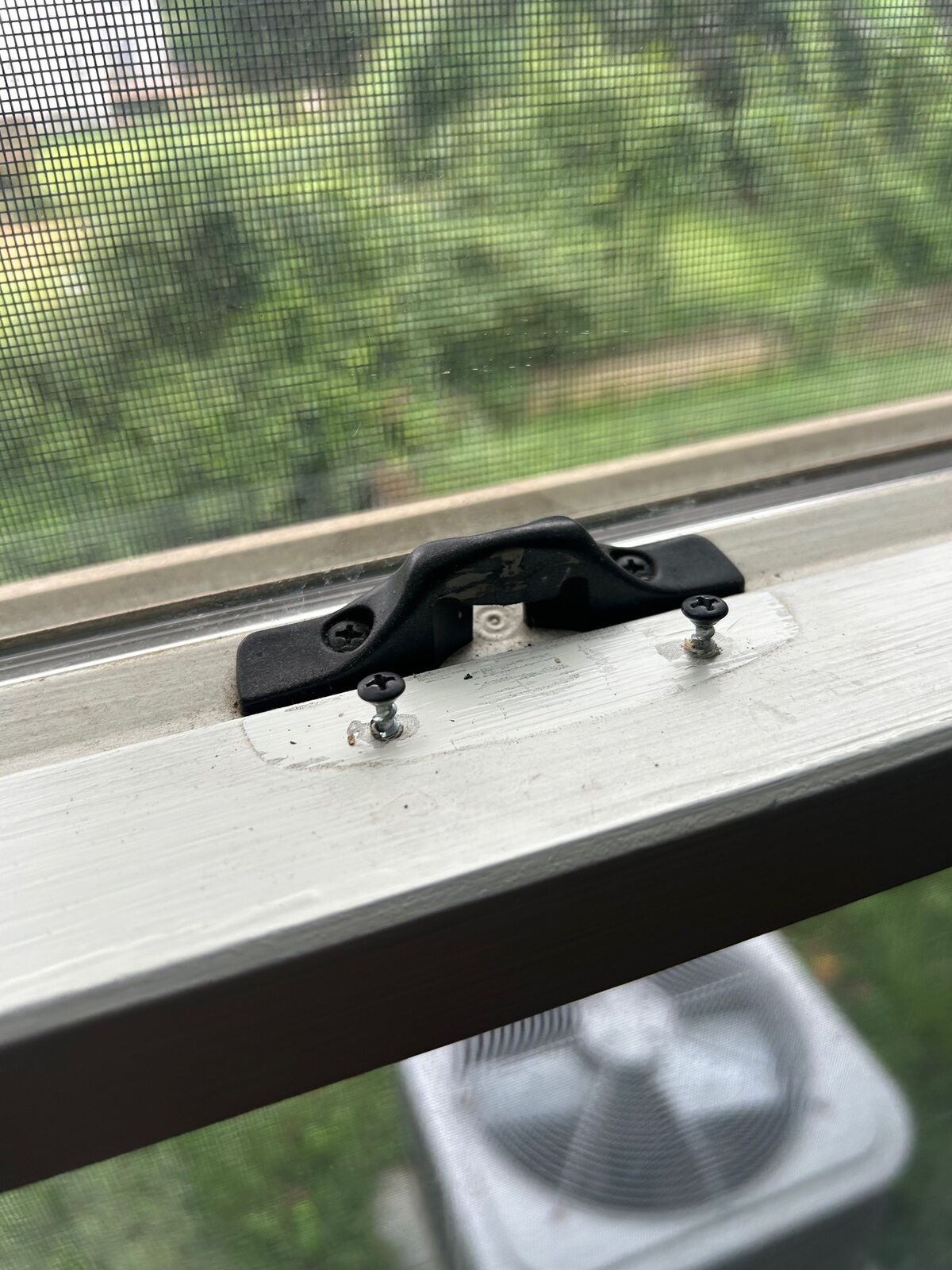 A black sash lock mounted on a window's meeting rail