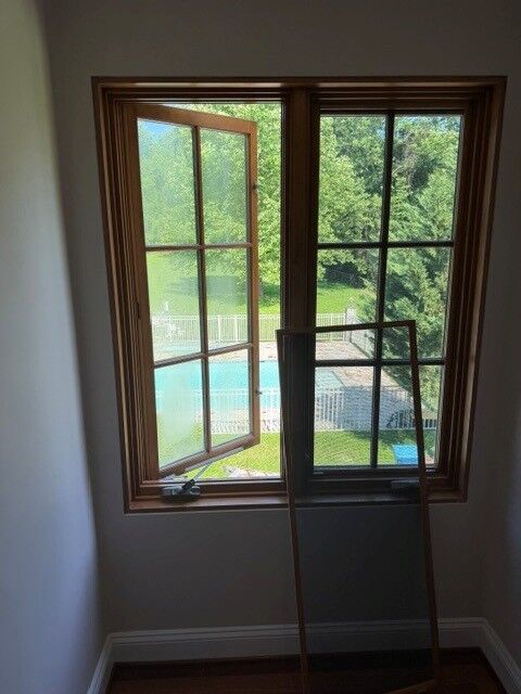 A wood-framed casement window opened inside a room